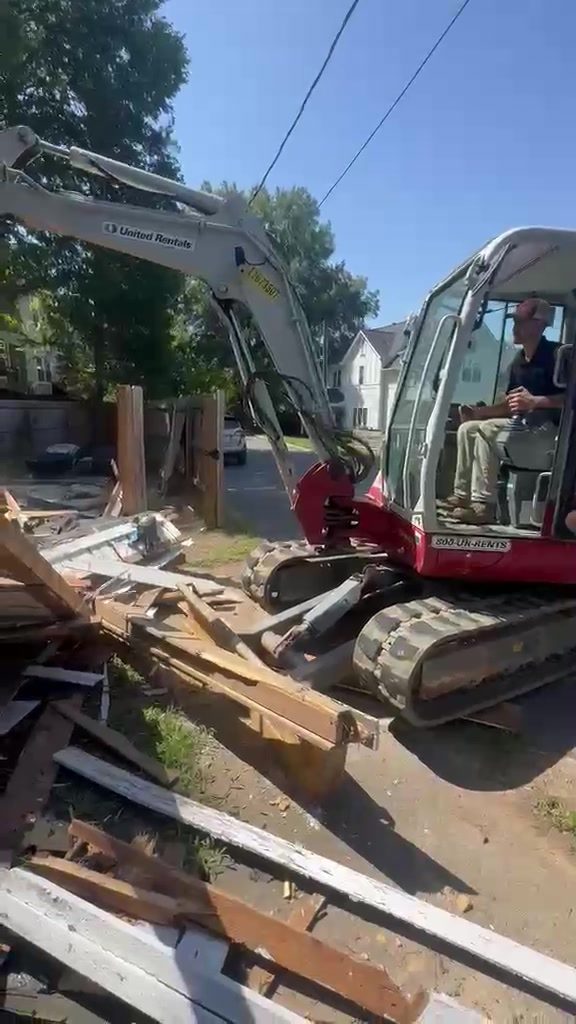 Mini excavator sorting demolition debris from a house teardown in Cornelius NC