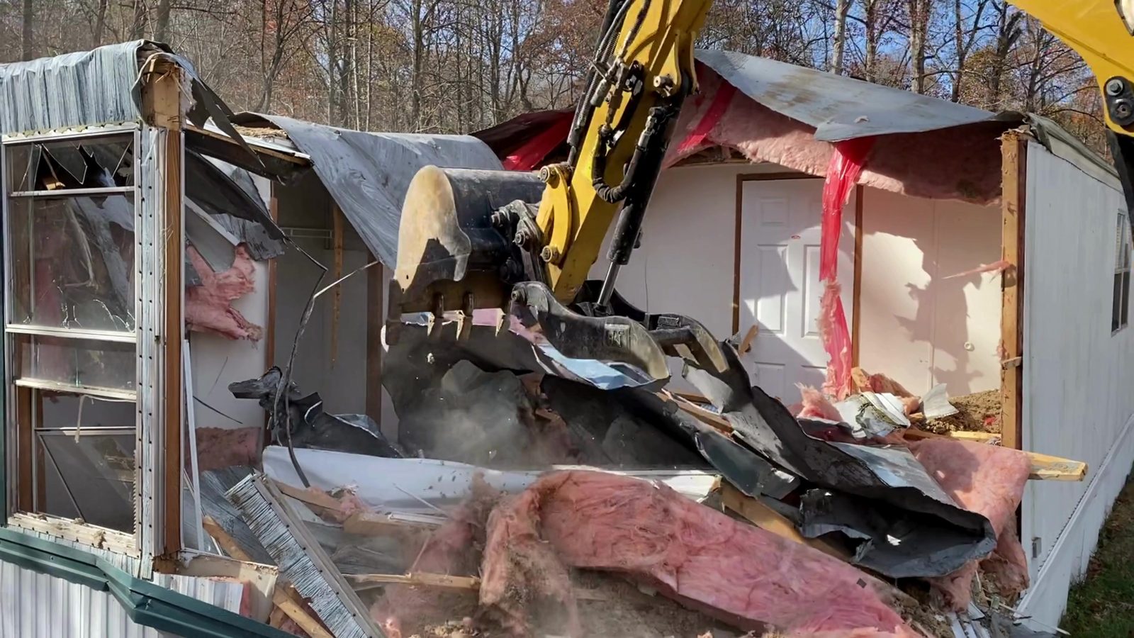 Excavator tearing through the frame of a mobile home in Denver NC